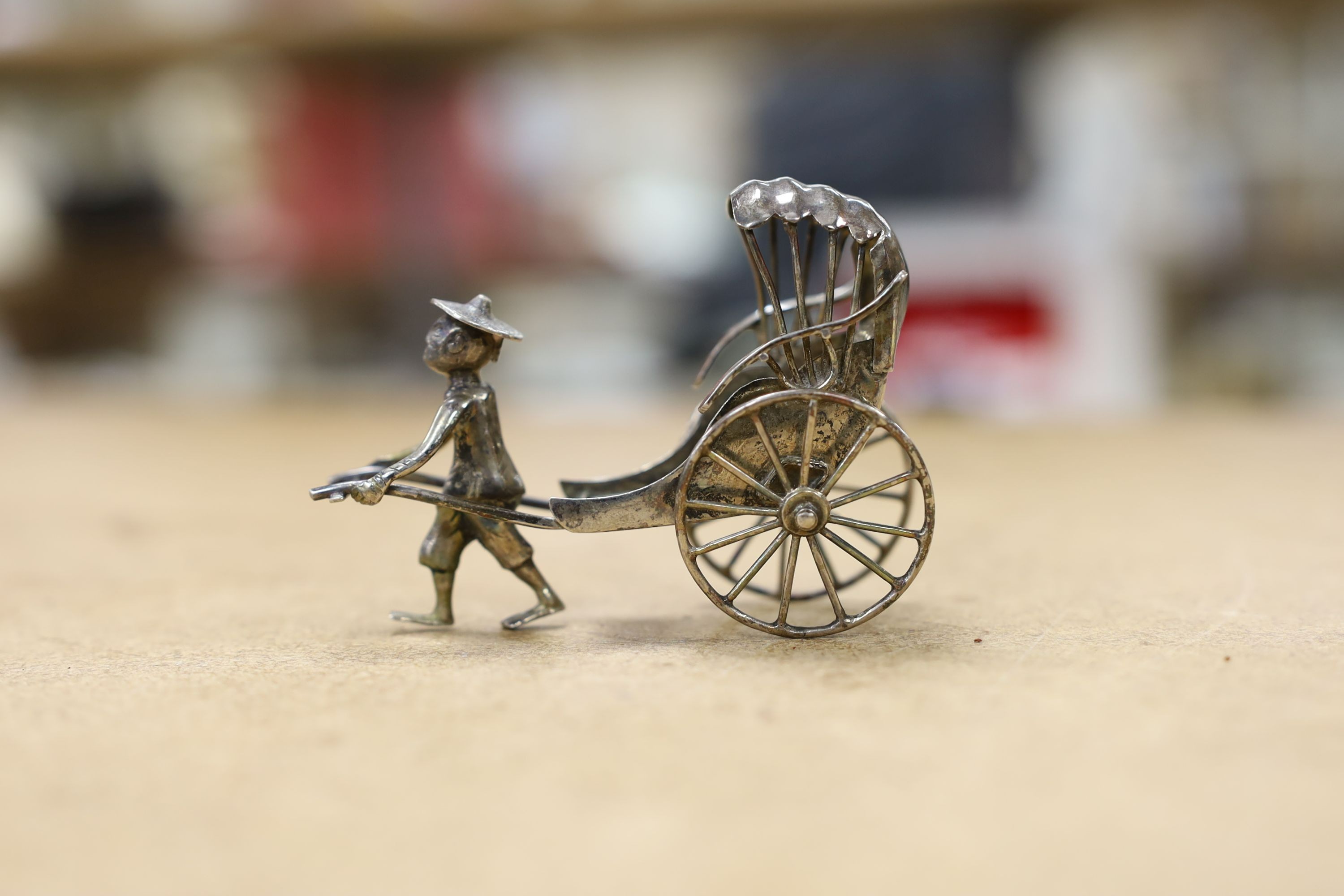 Six assorted miniature white metal items including a Chinese tea kettle on stand (lacking lid), height 93mm, maker CS, a similar rickshaw with driver, maker CH, a Chinese condiment and three other items.